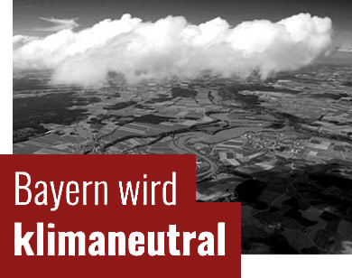 Das Bild zeigt eine Luftaufnahme einer Landscht; Das Bild trägt die Aufschrift Bayern wird klimaneutral