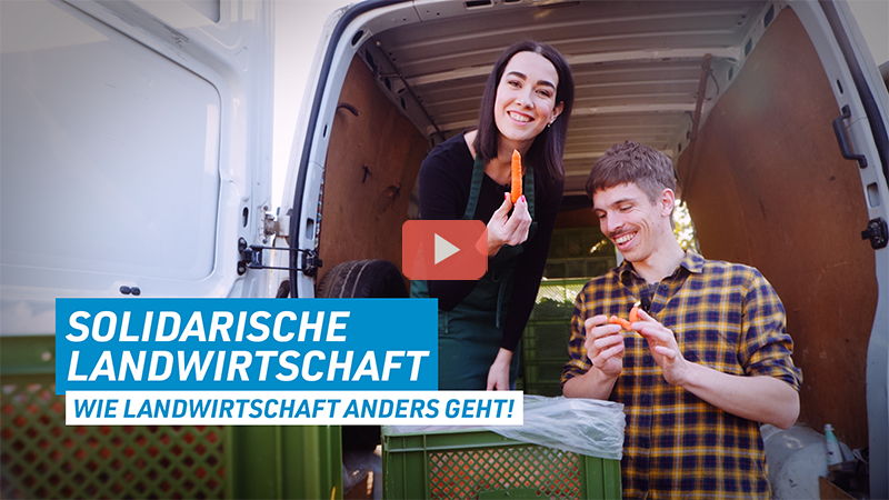 Sarah und Christian stehen an der offenen Ladefläche eines Transporters. Sieh haben jeweils eine Karotte in der Hand. Unten links steht der Schriftzug: Solidarische Landwirtschaft - wie Landwirtschaft anders geht!