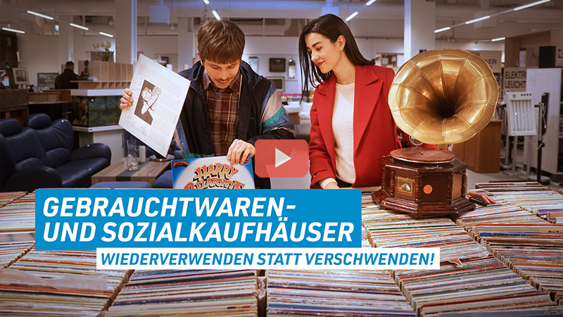 Sarah und Christian sind im Gebrauchtwarenhaus Halle2 und wühlen sich durch alte Vinylschallplatten. Unten links im Bild steht der Schriftzug: Gebrauchtwaren- und Sozialkaufhäuser, wiederverwenden statt verschwenden